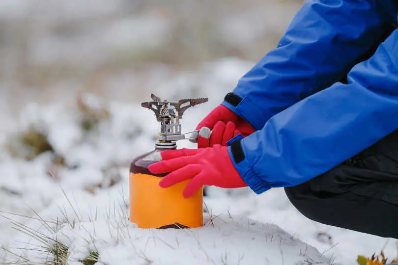 Man trying to light a fire on the stove in outdoor