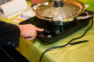 Chef cooking curry using a portable electric stove